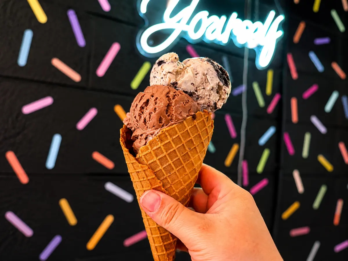 Scooped ice cream cone in hand
